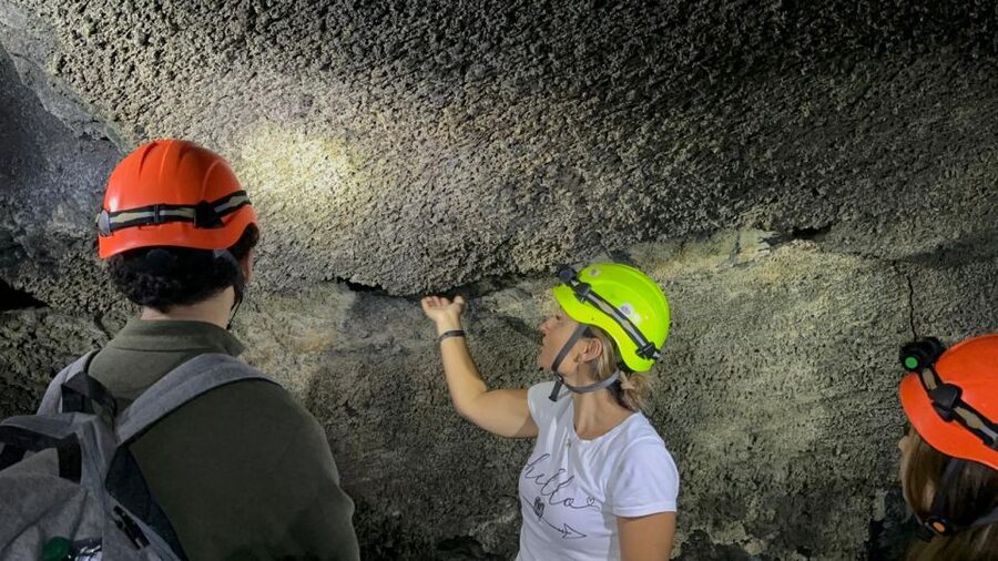 Catania: Etna Morning or Sunset Trek with Lava Tunnel & Gear - Entering the lava tunnel with a helmet and flashlight